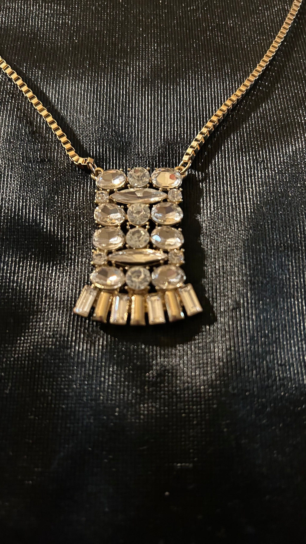 vintage-style gold-tone piece featuring a rectangular, crystal-encrusted pendant