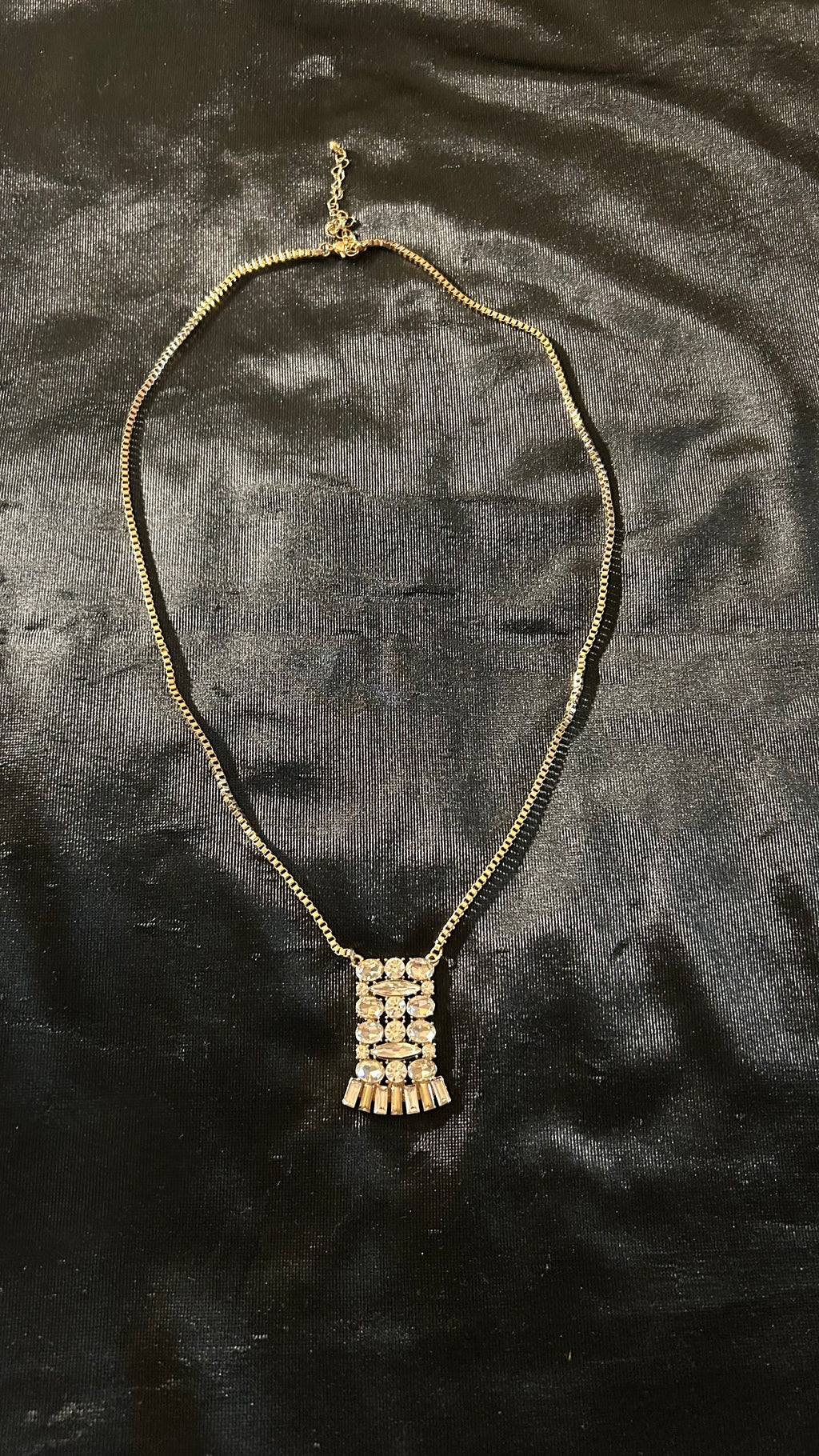 vintage-style gold-tone piece featuring a rectangular, crystal-encrusted pendant