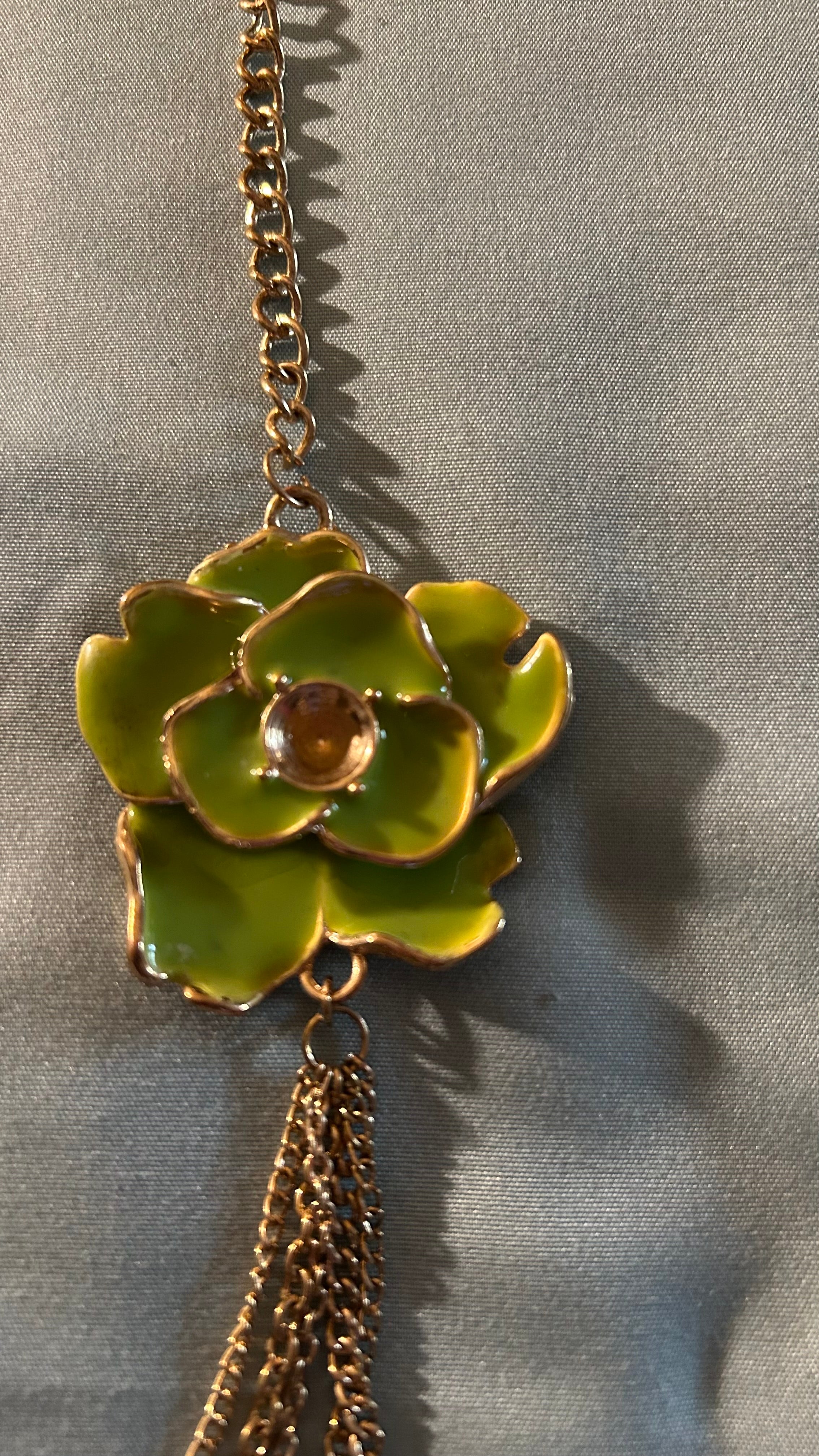 Gold-tone multi-chain accessory featuring a light green floral charm